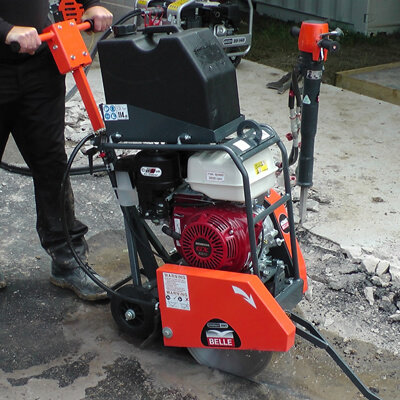 A Floor Saw Petrol - 350mm being operated outside.