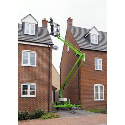 A Nifty 120 Trailer Mounted Boom Lift being used to work at heights on a house.