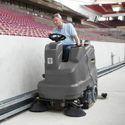 A Karcher (B 90/150 R) Ride-on Floor Scrubber Dryer being used in a stadium.