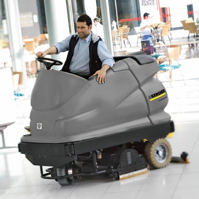 A Karcher (BR 100/250) Ride-on Floor Scrubber Dryerbeing operated inside of a shopping centre.