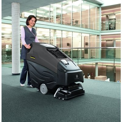 A Karcher (BRC 50/70) Professional Carpet Cleaner - Battery Powered being used by a woman in an office building.