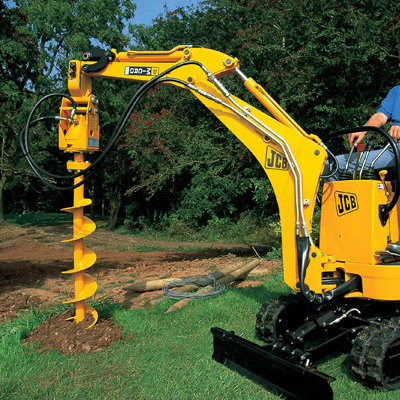 An Excavator Auger Drive being used to drill a hole in a garden.