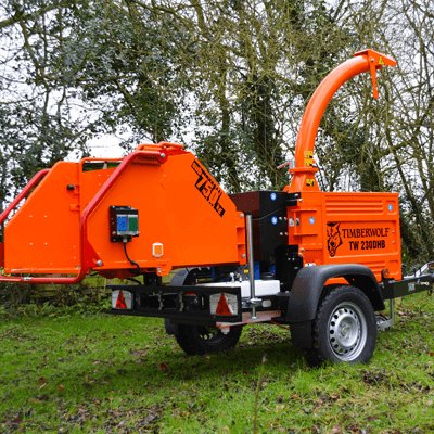 A Diesel Road Tow Wood Chipper being used in a wooded area.