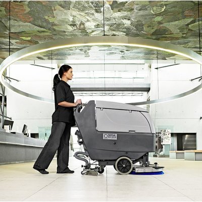 A Nilfisk BA611 Floor Scrubber Dryer being operated in a workplace.