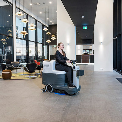 A Nilfisk SC2000 Ride-on Floor Scrubber Dryer being used in an office building.
